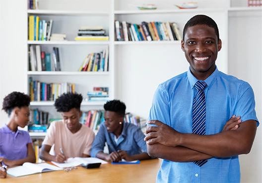A young male student standing with folded arms with a smile 