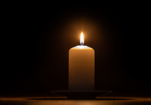 A lit candle at a funeral.